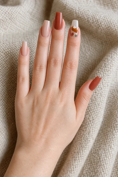 Pumpkin pie and leaf Thanksgiving nail art on medium oval nails with glossy finish, diagonal hand pose, rich dark brown skin tone