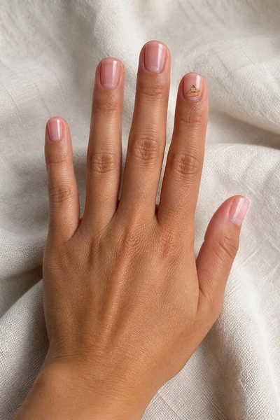 Minimal pumpkin pie line art on short square nude nails, glossy relaxed hand pose, medium skin tone