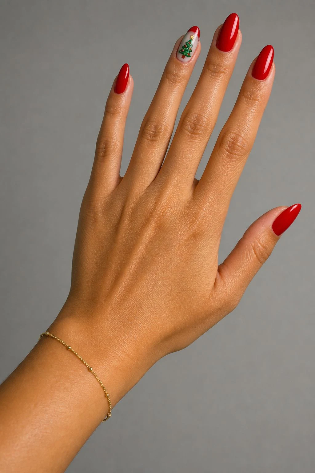 Red With a Green Tree Accent Christmas nails with a delicate gold bracelet