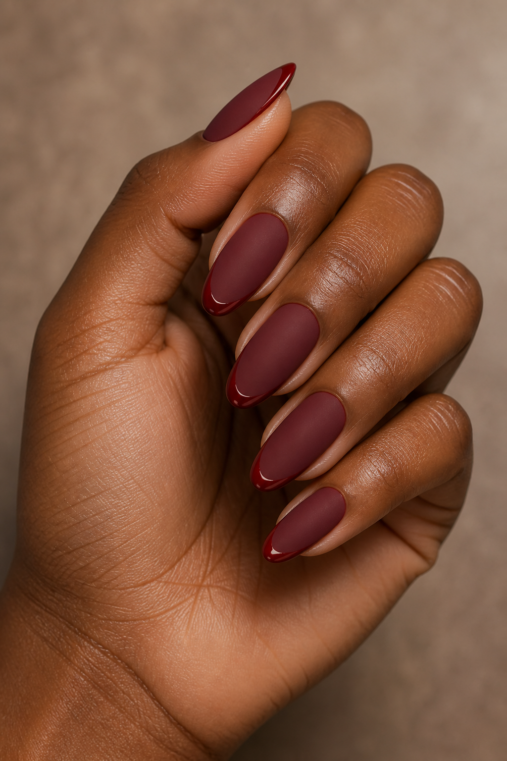 Matte garnet almond Christmas nails with glossy red edges.