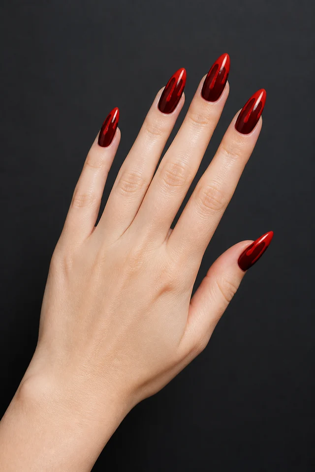 deep red almond Halloween nails with glossy blood-red chrome on a fair hand and visible wrist in soft daylight