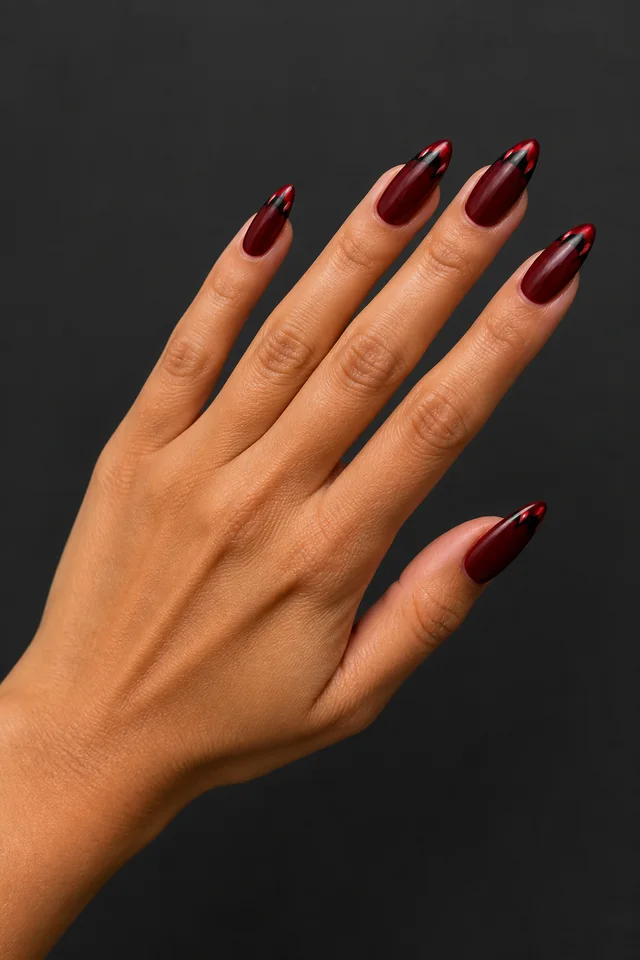 red oval nails with tiny ghost details on a tan hand in natural daylight