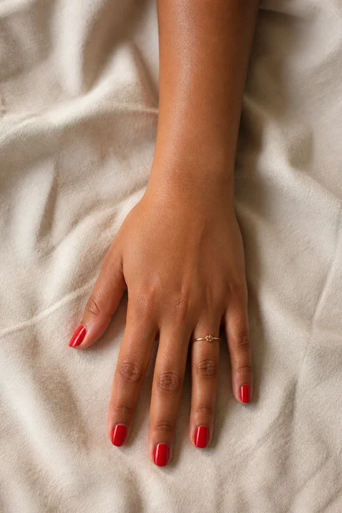dramatic glossy red stiletto nails on a rich brown hand with visible wrist