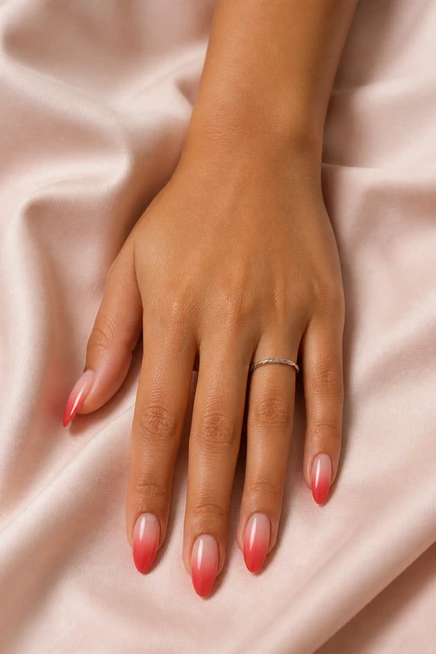 red to nude ombre almond nails on a rich deep skin tone hand with visible wrist