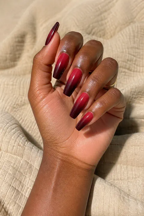 red and creamy white glossy ombre soft square nails on a light skin tone hand with visible wrist