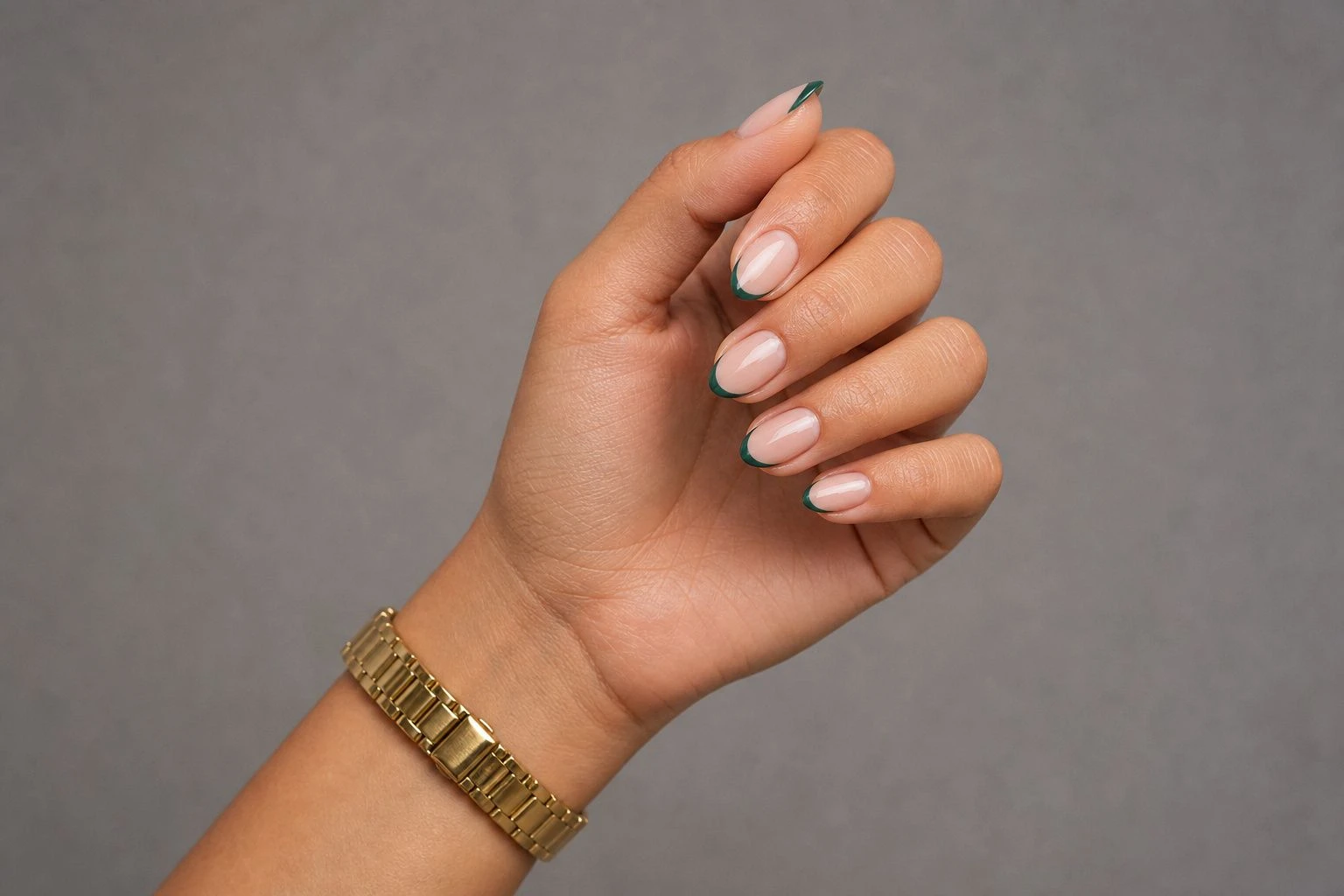 Short almond fine emerald green line French tip manicure with a slim gold watch, simple Christmas nail idea