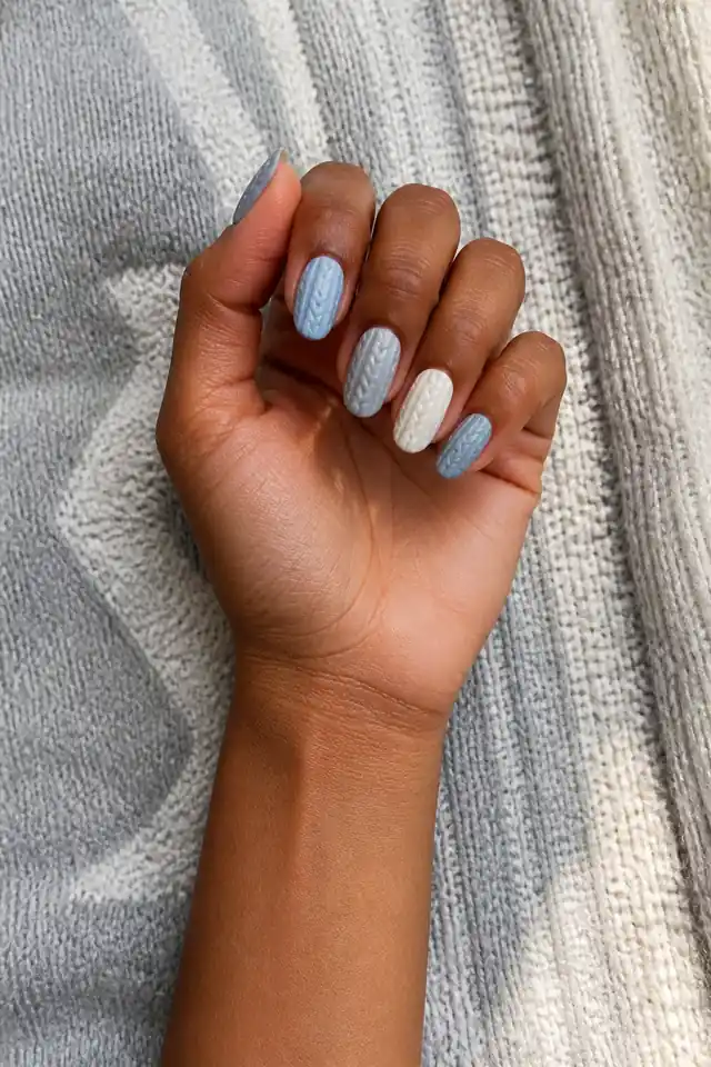 Cable texture and glossy ribbed companion nails on medium almond nails, mixed finish, fair skin, hand angled in natural daylight with visible wrist
