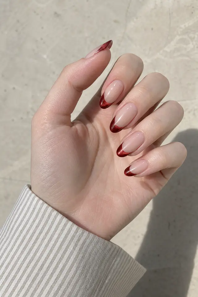 garnet magnetic red nails on a tan hand with a visible forearm