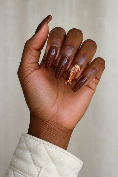 Deep cranberry oval nails with cream turkey feather fan, glossy angled hand pose, tan skin tone