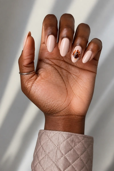 Long almond turkey illustration nails with harvest leaves, glossy angled hand pose, light olive skin tone