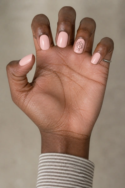 Blush nails with cocoa turkey line drawing on short oval shape, glossy angled pose, medium skin tone