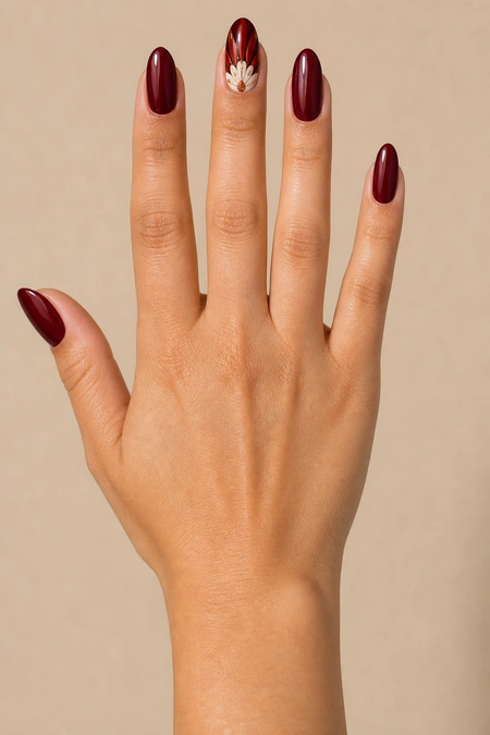 Cranberry oval turkey feather fan nails with glossy finish, relaxed diagonal hand pose, tan skin tone