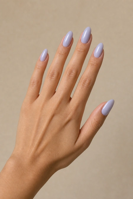 Icy lilac acrylic almond nails on a side-angled hand pose with visible wrist, light olive skin tone, soft window light